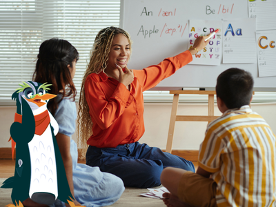 Lady teaching two kids spelling patterns from a whiteboard with Professor Penguin. 
