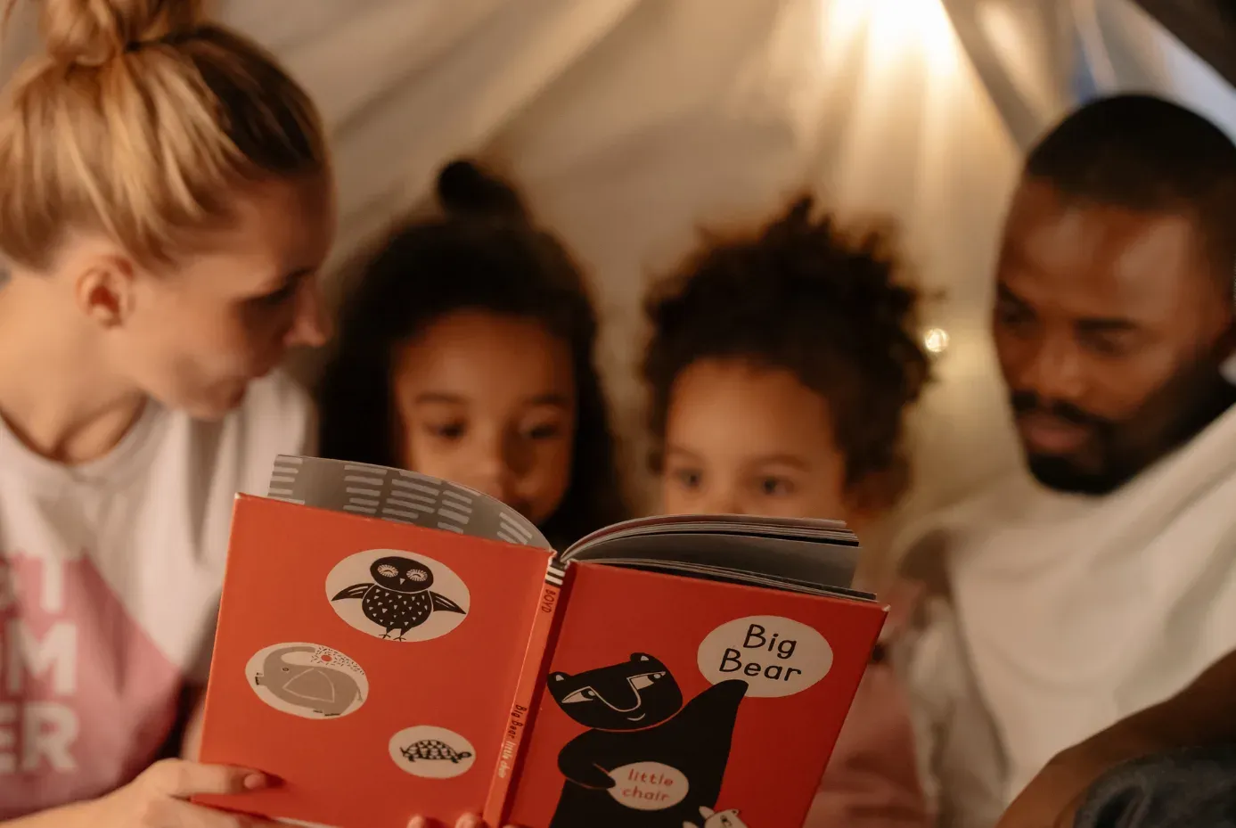Family reading a book together.
