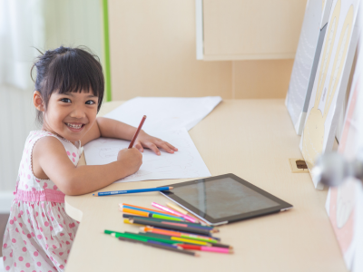 Child grinning at desk