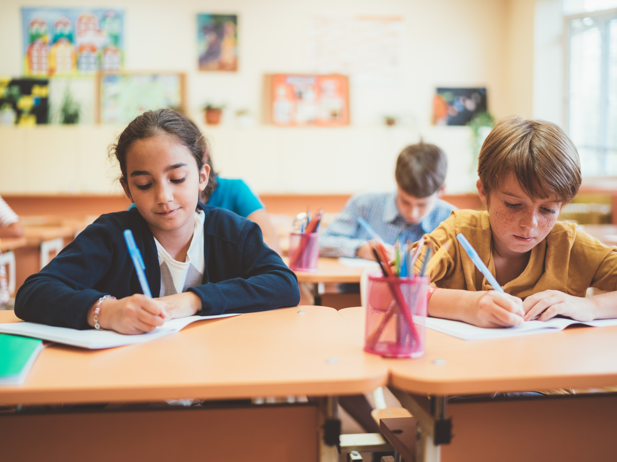 Children writing in a classroom.