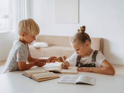 Two children, writing together.