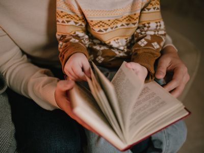 Parent and child holding a book.