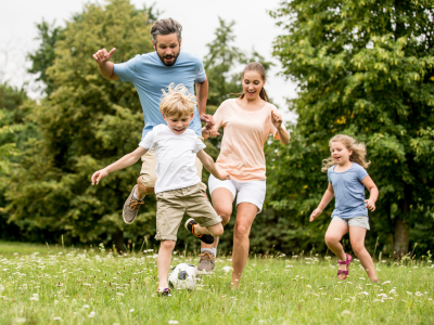 Family playing soccer outside.