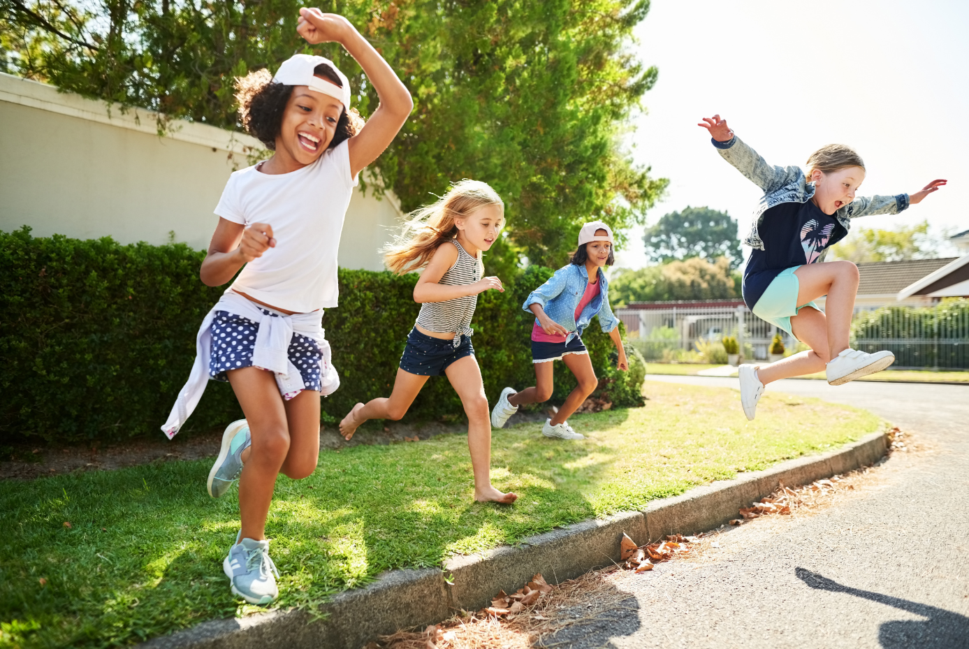 Four children running and laughing together.