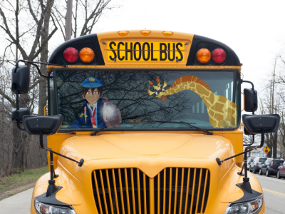 Night Zookeeper Will and Sam the Giraffe on a school bus. 