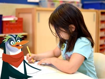 Child writing on a piece of paper at desk, with Professor Penguin.