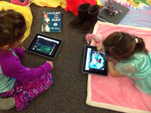 Children on blankets with ipads.