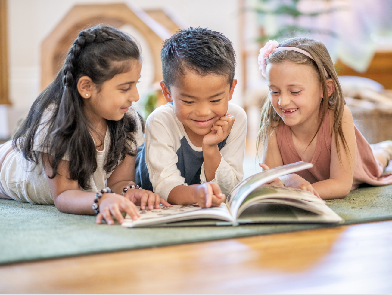 Three children reading a book.