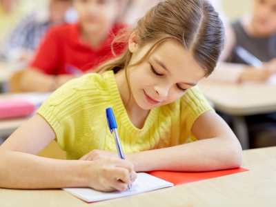 girl writing while smiling