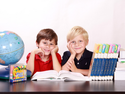 Two boy students with school supplies