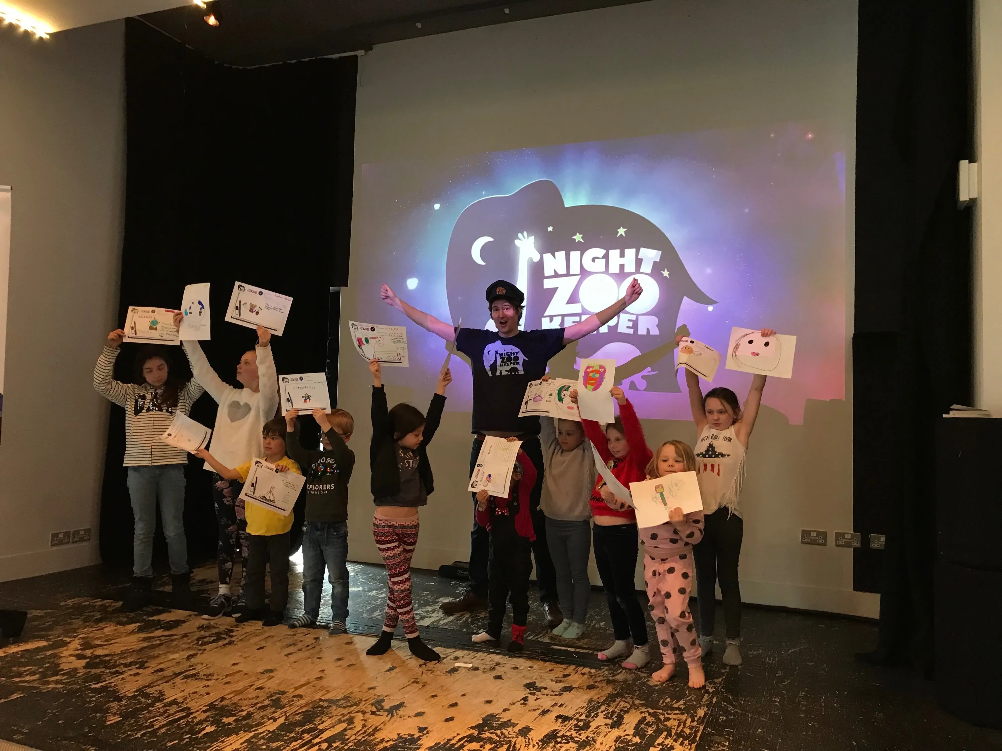 Kids and Josh holding up their drawings.